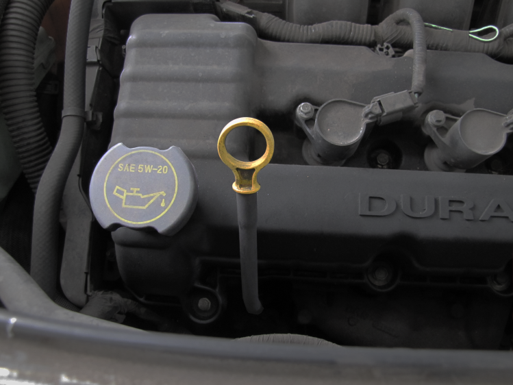 The oil filler cap on this Ford V6 is right next to the dipstick. The cap will usually tell you what kind of oil should be in the engine.